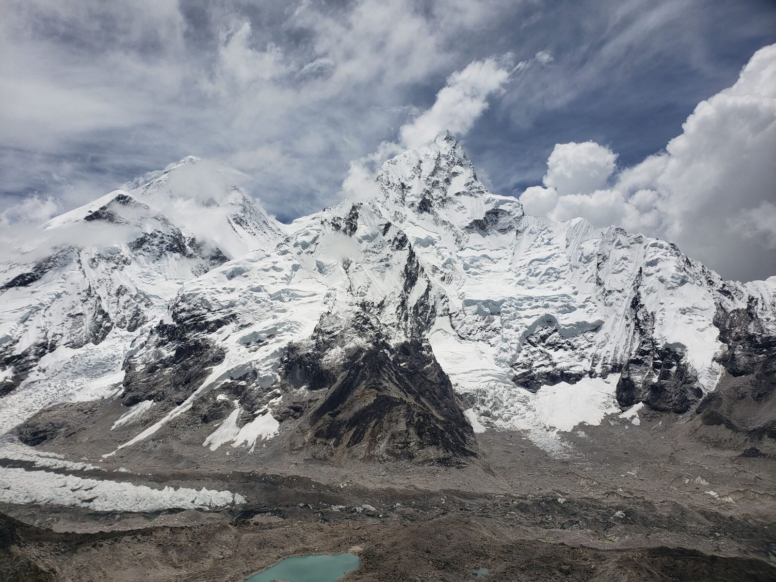 Stunning capture of snow-capped peaks in the Himalayas under a cloudy sky, Khumjung, Nepal.